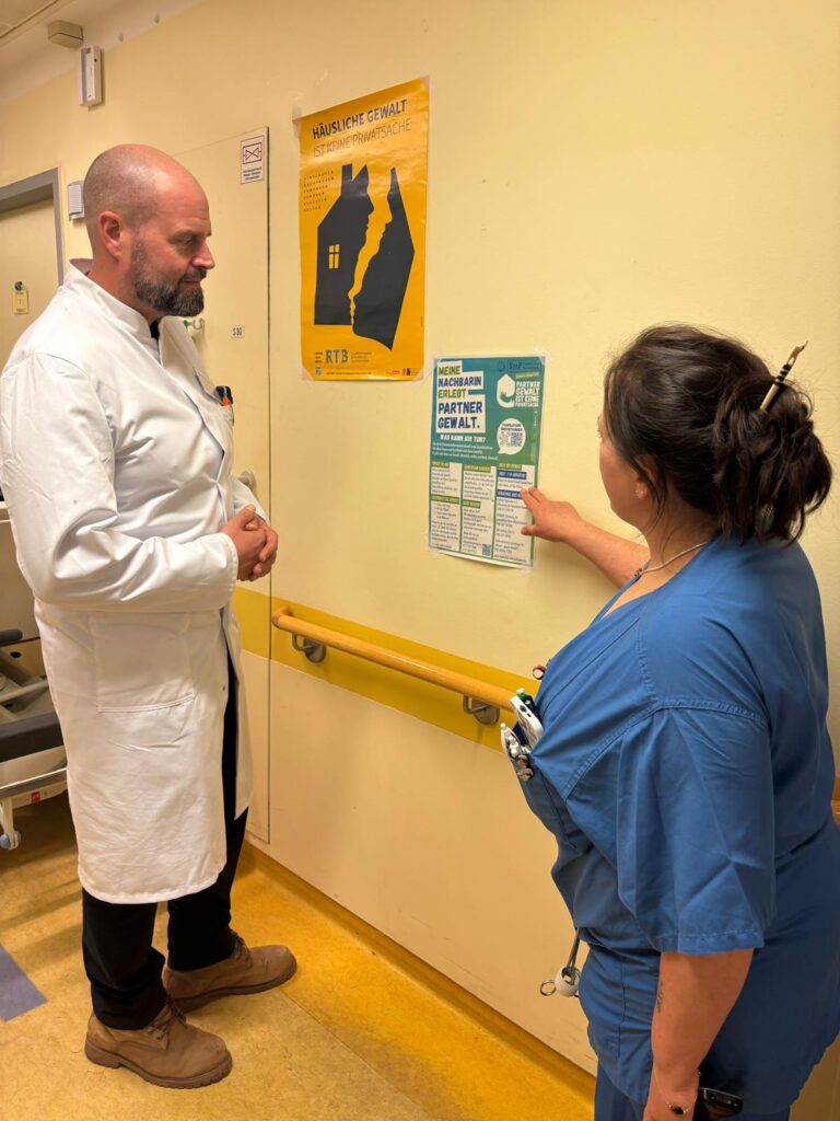 Medizinisches Personal liest einen Aushang von StoP im Krankenhaus