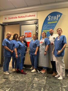 Mitarbeitende in der Notaufnahme vor einem StoP-Banner