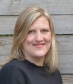 Im Hintergrund Holzbretter und eine lächelnde Frau mit mittellengen blonden Haaren.