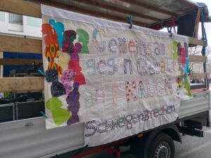 Ein besticktes Banner mit der Forderung: Gemeinsam gegen Gewalt an Frauen # SchweigenBrechen