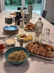 Ein weißer langer Tisch mit Frühstück.