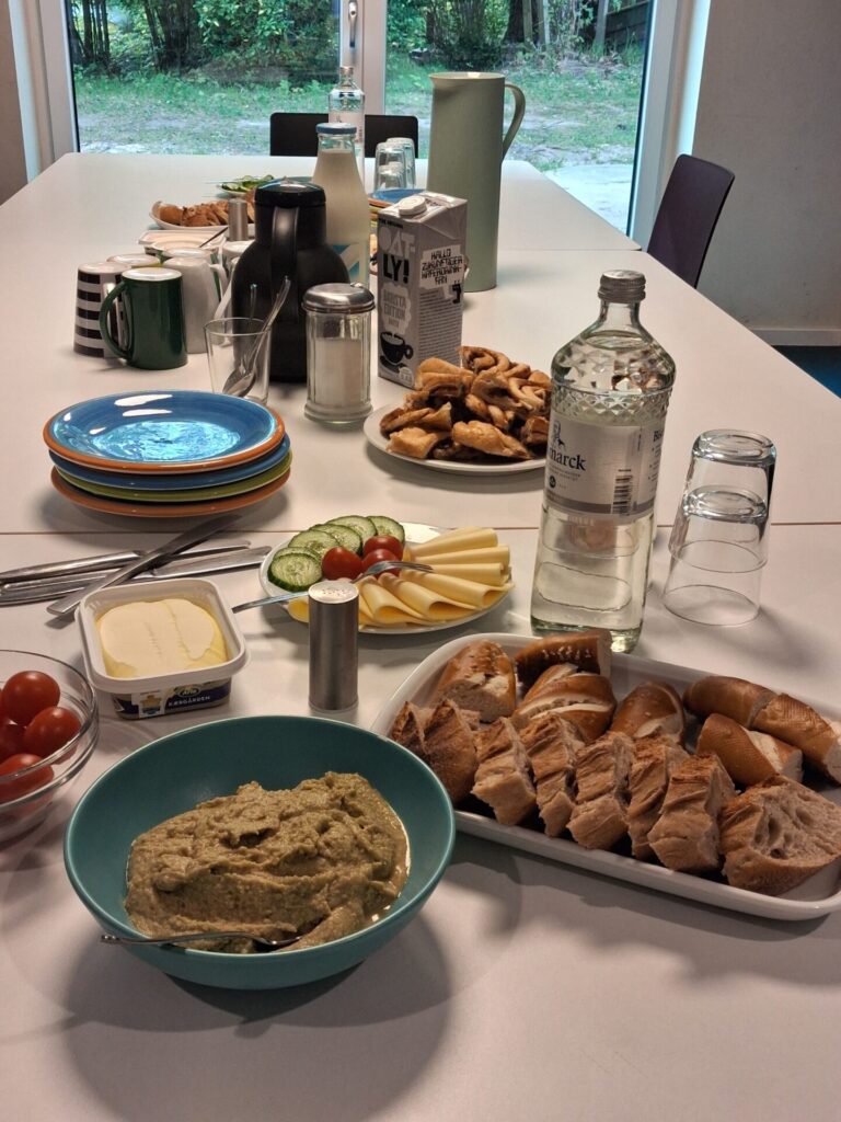 Ein weißer langer Tisch mit Frühstück.