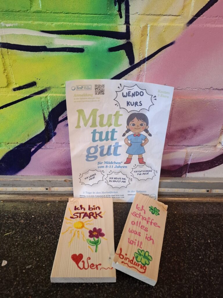 Flyer und durchgetretenes, bemaltes Brett mit der Aufschrift "Ich in stark!".